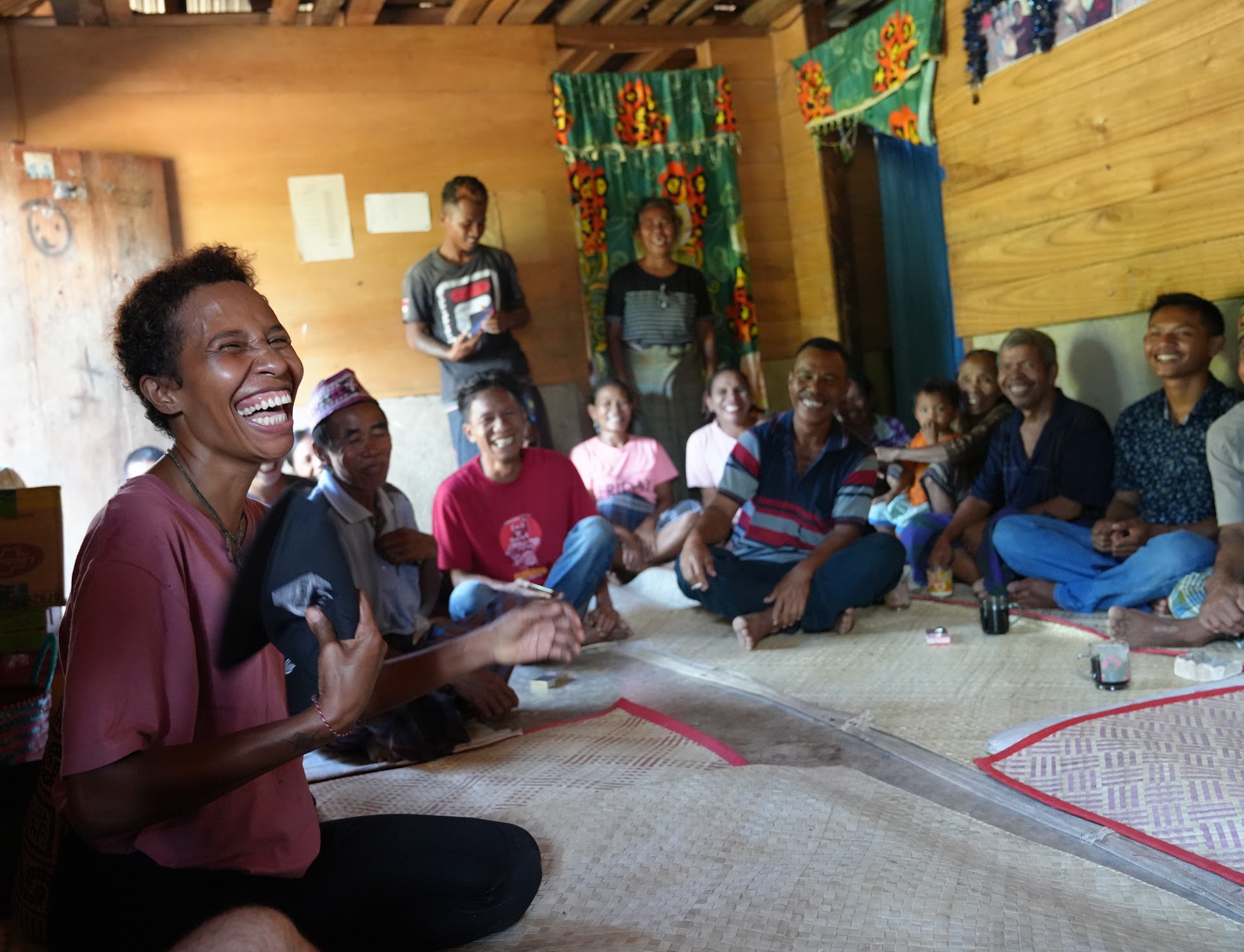 A community gathering indoors, with a woman laughing in the foreground